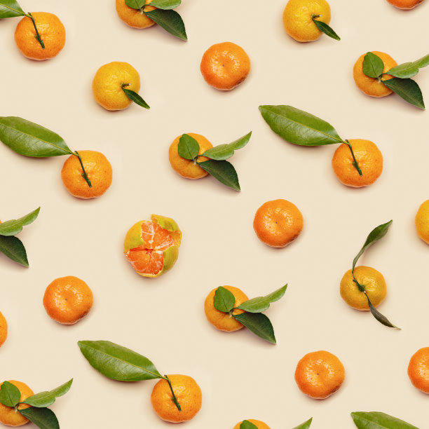 成熟新鲜的橙黄色橘子，绿叶，整个去皮，米色背景，时尚的图案。柑橘类水果，静物美学照片，创意布局，素食图片下载