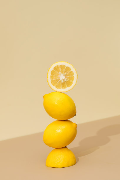 米色背景上多汁的黄色柠檬金字塔。创意水果概念，柑橘类水果。图片下载