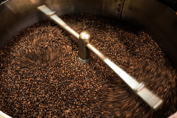新鲜咖啡豆烘焙纺纱罩专业机近距离柔焦慢速快门速度因为想要使咖啡豆细节的运动模糊概念，在工厂泰国清莱，图片下载