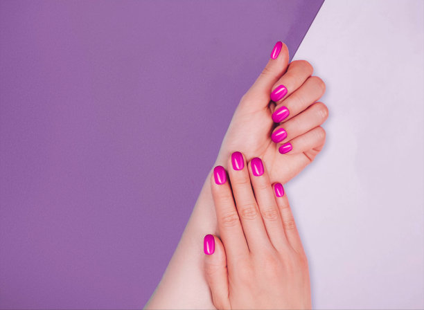 一个年轻女子的手特写，她的指甲上涂着粉红色的指甲图片下载