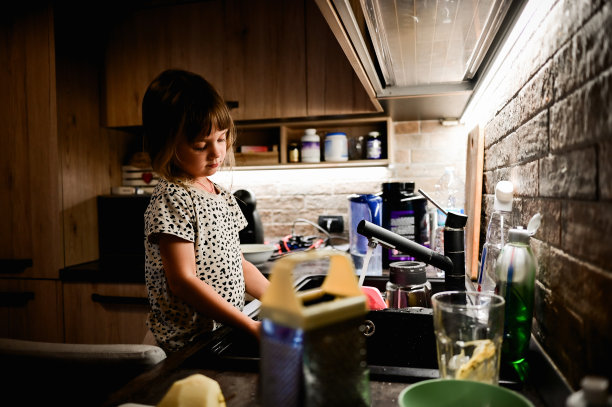 现实生活的概念。小女孩帮妈妈洗碗。图片下载