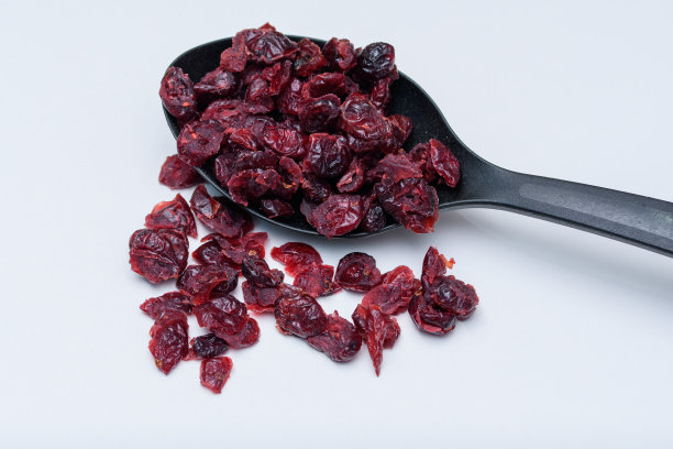 用黑色厨房勺子盛蔓越莓干图片下载
