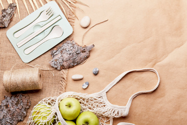 美观环保，零浪费，可持续的生活方式背景，可重复使用的袋子，餐具，苹果，树皮，鹅卵石在制作纸与复制空间。图片下载