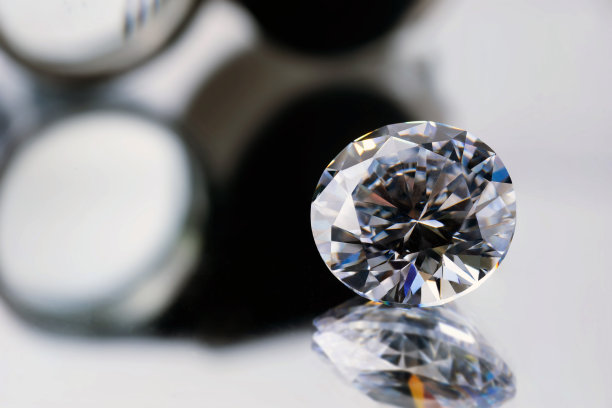 在黑色背景上，用镊子夹住明亮的切割钻石图片下载