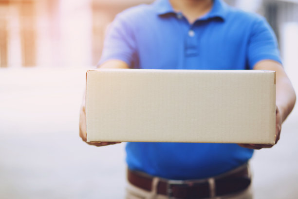 包裹递送员:通过服务递送包裹的人。而近手的女顾客则从快递员手中接过快递箱，直接寄回家。图片下载
