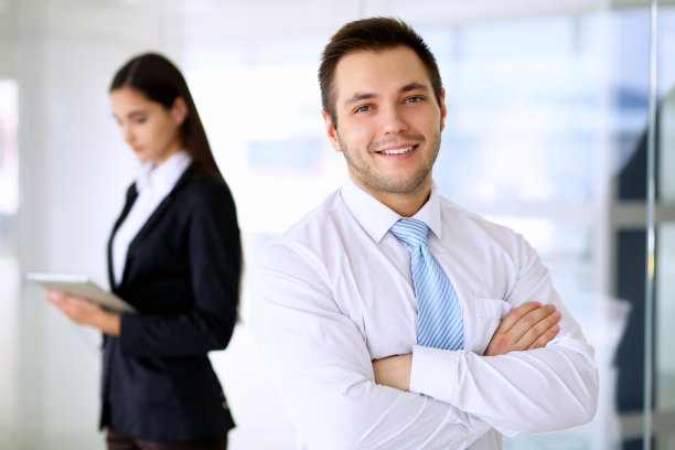 微笑的商人在办公室与同事在后台图片下载