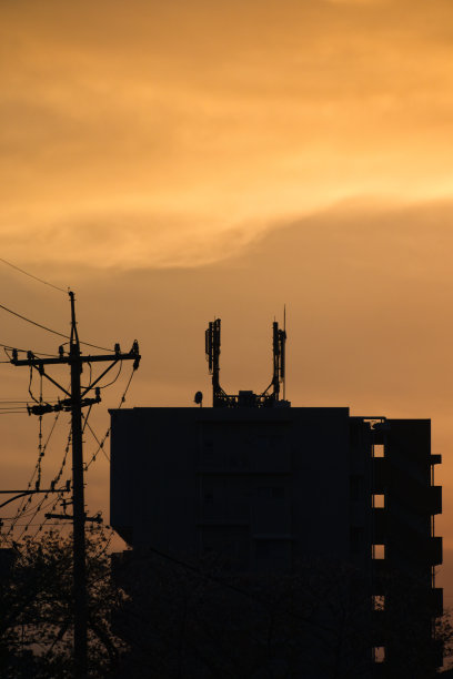 黄色朦胧的天空和日落时建筑物的剪影图片下载