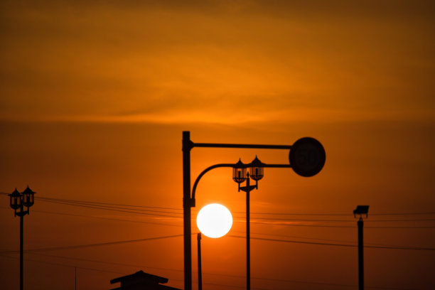 黄色朦胧的天空和日落时建筑物的剪影图片下载