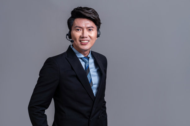 男呼叫中心接线员戴着耳机做广告手势。欢欣鼓舞的图片下载