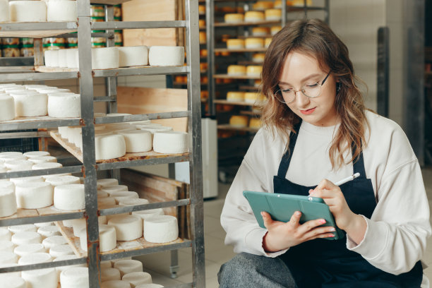 年轻的农场女主人控制山羊奶酪头的成熟过程图片下载