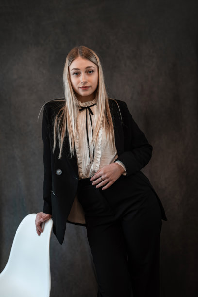 一个现代时尚的白人妇女的肖像穿着经典的黑色西装孤立在黑色图片下载