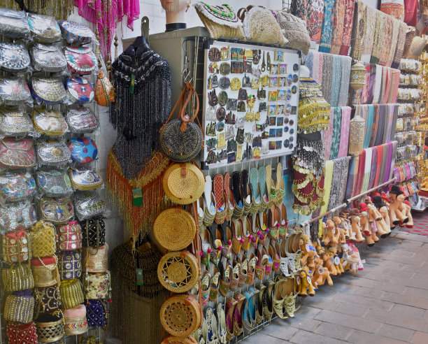 在迪拜的纺织品市场或露天市场上展示的羊绒披肩和传统鞋类图片下载