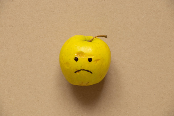 绿色的思念苹果，用棕色的纸画着悲伤的微笑，悲伤和悲伤，食物图片下载