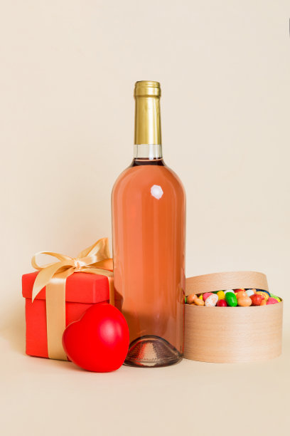 一瓶酒在彩色背景情人节与礼盒。带有当前框透视图的心形，带有复制空间图片下载