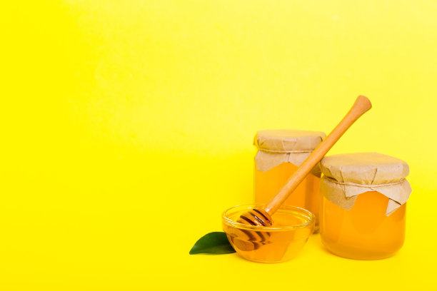 蜂蜜与叶子和蜜罐在彩色背景顶部视图与复制文本图片下载