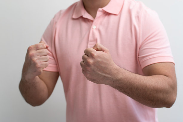 在白色背景下，一名男子在镜头前用拳头欢呼图片下载