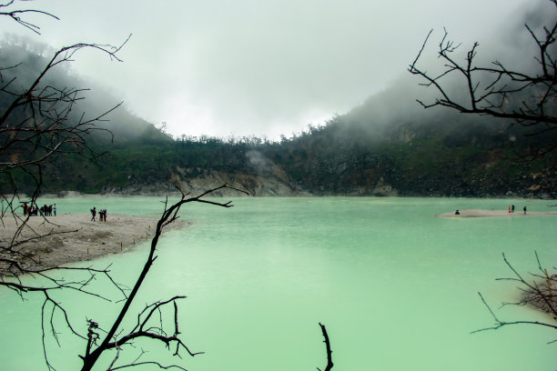白色的火山口，前景是木质的树枝图片下载
