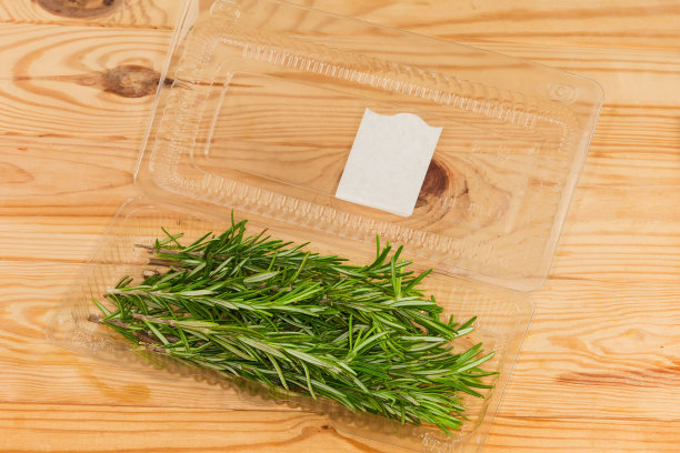 新鲜的迷迭香枝，放在敞开的塑料容器里，放在质朴的桌子上图片下载