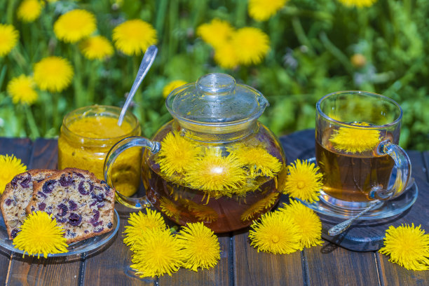 木桌上的玻璃茶壶里盛着健康的蒲公英花茶，还有春天花园里的甜果酱和樱桃松饼图片下载