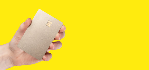 银行信用卡模拟手在黄色横幅背景图片下载