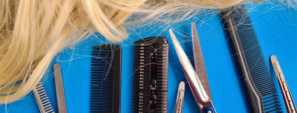 理发师工具梳剪刀和头发在蓝色的背景图片下载