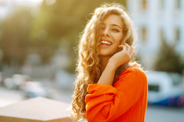 美丽的女人在城市风景的背景下摆姿势。图片下载