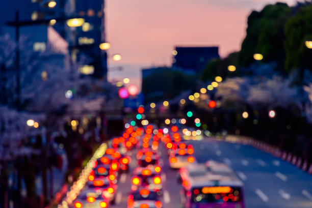 为抽象的交通运输背景，对城市黄昏交通拥堵中的汽车灯光进行散焦模糊图像处理。图片下载