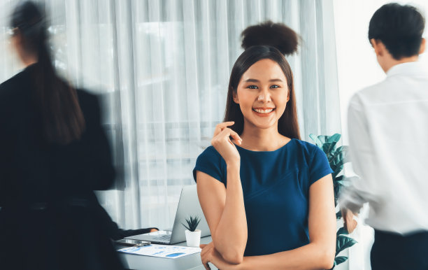 年轻的亚洲女商人在繁忙的会议室里自信地摆姿势。康科德图片下载