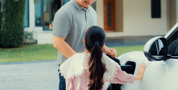 父女俩电动车和家庭充电站的进步概念图片下载