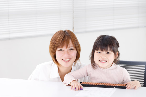 一位老师正在一个小教室里指导学生。这个女学生很积极，很享受图片下载