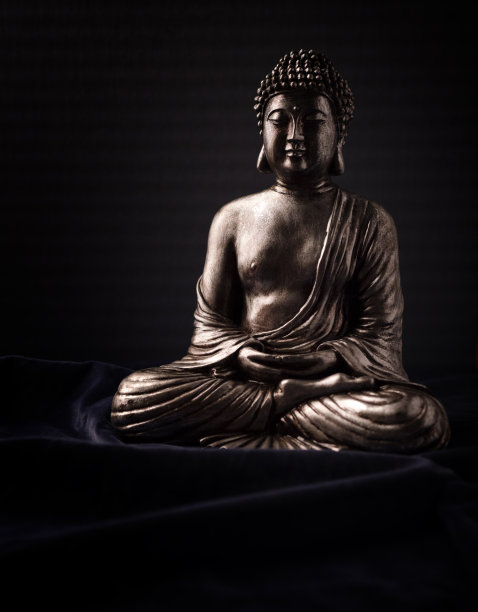 冥想佛像在黑暗的背景。软的焦点。关闭了。副本的空间。图片下载