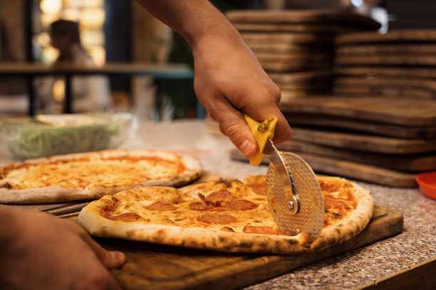 匿名披萨厨师切美味披萨的特写图片下载