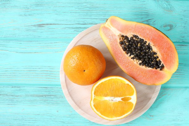 异国的水果木瓜、柠檬和橘子放在木桌上，平铺着图片下载