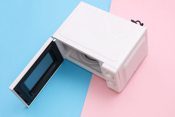 微波炉，门是敞开的，背景是蓝粉色。俯视图图片下载