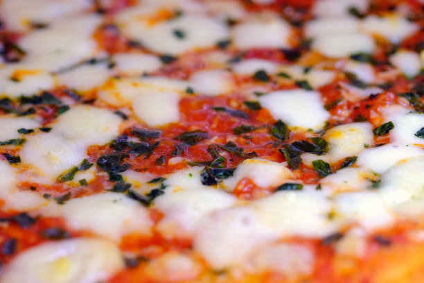 玛格丽塔披萨有马苏里拉奶酪、西红柿、红酱和新鲜罗勒，特写食物背景纹理。意大利披萨微距照片。图片下载