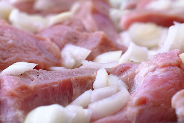 生猪肉切碎块与洋葱和黑胡椒准备烹饪特写食物背景纹理微距照片。在家做饭。杂货店或肉店的新鲜农产品。图片下载