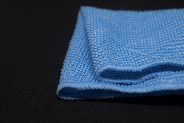 黑色的桌子上放着一条柔软的浅蓝色毛巾图片下载