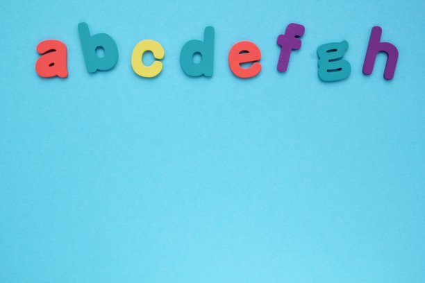 蓝色背景上的木制彩色字母。教育和返校的概念。外语学习图片下载