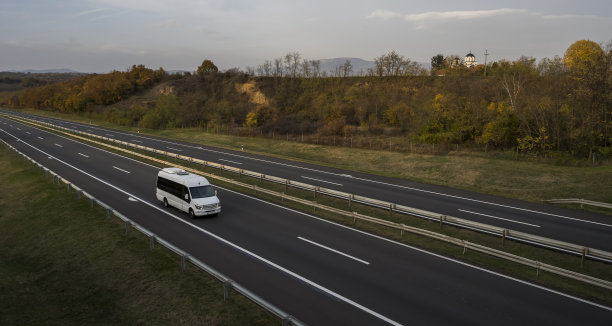 白色现代舒适的旅游巴士行驶在高速公路上。旅游和旅游车旅游的概念。乘车旅行和旅行。图片下载