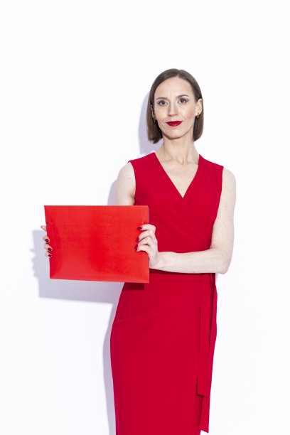 性感的肖像迷人的积极自信的高加索商务女性在红色长裙展示红色文件夹在白色图片下载