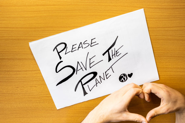 手做一个心脏与卡片在桌子上拯救地球，在纸板上的信息拯救地球，在纸板上手写的概念拯救地球图片下载