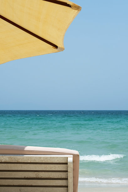 阳光躺椅和沙滩伞对着海景。励志心情热带度假胜地。图片下载