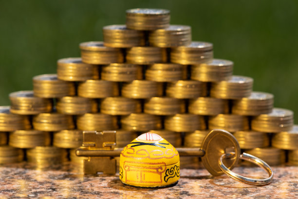 一个金色的库奇和一个象征性的哈萨克微型蒙古包，背景是面值为100坚戈的哈萨克硬币金字塔图片下载