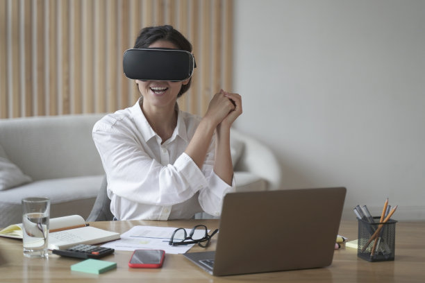 年轻的女玩家带着虚拟现实眼镜在工作中玩模拟游戏图片下载