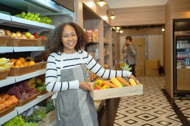 在迷你超市卖蔬菜、水果和各种食物的快乐女人图片下载