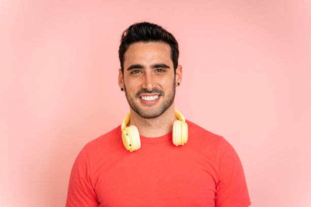 摄影棚里戴着耳机的微笑男子。图片下载