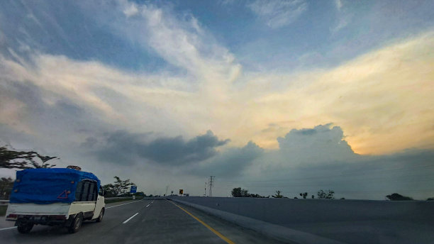 小货车在日落时分行驶在高速公路上图片下载