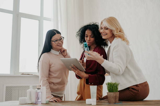 三个快乐的成熟女性一起在网上购买美容产品图片下载