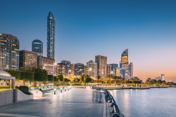 阿布扎比天际线日落美景，摩天大楼反射天空的暖色调。图片下载