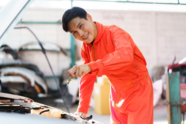 技师正在检查发动机润滑油。图片下载